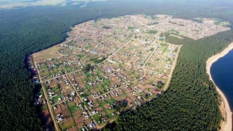 2022, according to the source caption. The relocated village has streets, homesteads, forest and a reservoir shore. It is not a repeat view from the same position as the old Tangui panorama.