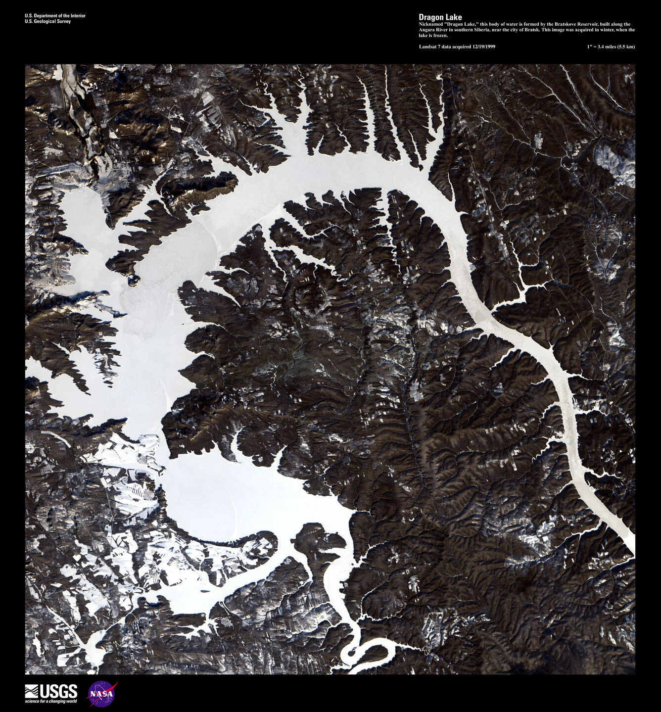 Landsat 7 image in the USGS Earth as Art collection. The page carries 1 December 1999 and describes winter acquisition over the frozen reservoir. “Dragon Lake” is an imaginative collection title rather than an official local place name.